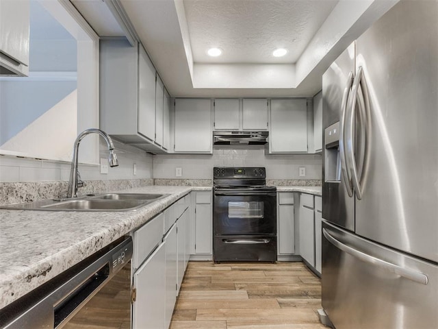 kitchen with black / electric stove, a sink, stainless steel fridge with ice dispenser, dishwasher, and light wood finished floors