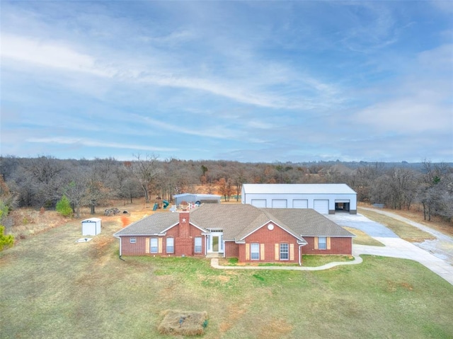 view of front of home featuring a detached garage, an outdoor structure, and a front yard