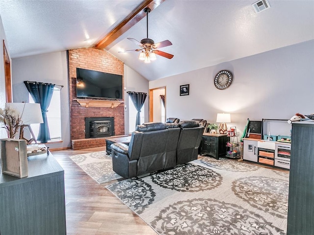 living room with ceiling fan, visible vents, vaulted ceiling with beams, and wood finished floors