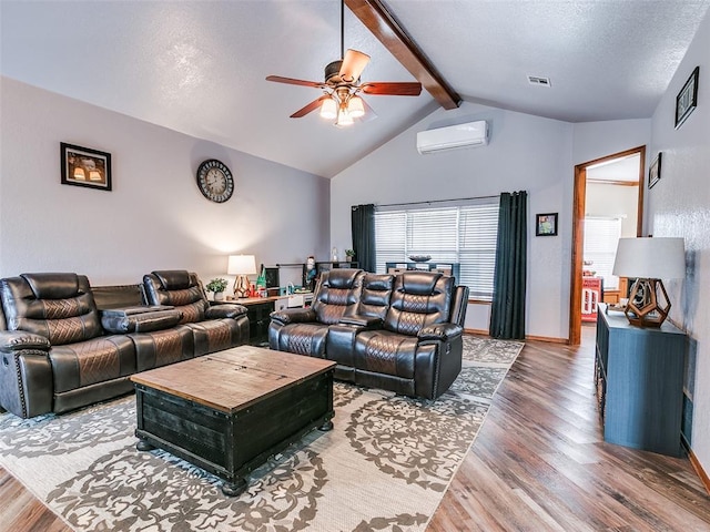 living room with vaulted ceiling with beams, a wall mounted AC, wood finished floors, and visible vents