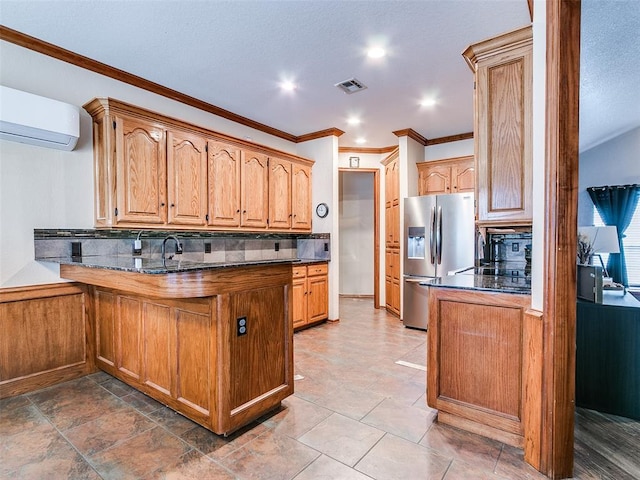 kitchen with a peninsula, visible vents, backsplash, a wall mounted air conditioner, and stainless steel fridge