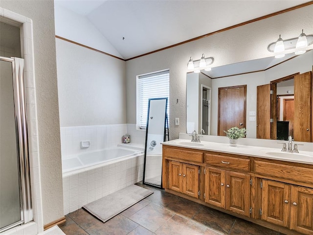 bathroom with a stall shower, vaulted ceiling, a sink, and double vanity