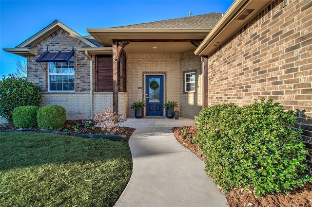 doorway to property featuring brick siding