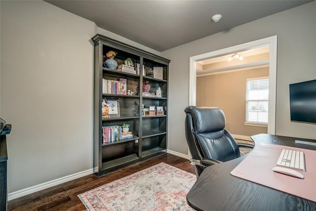 office area featuring a tray ceiling, baseboards, and wood finished floors