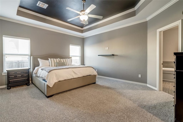 carpeted bedroom featuring visible vents, a raised ceiling, baseboards, and ornamental molding