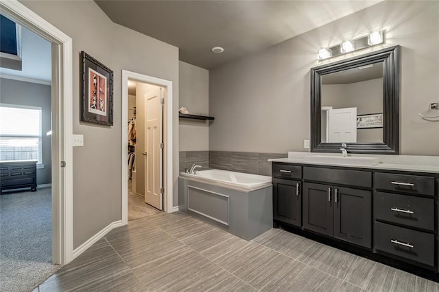 bathroom with vanity, a garden tub, and baseboards