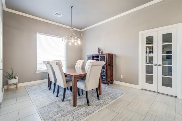 dining room featuring a notable chandelier, baseboards, visible vents, and ornamental molding