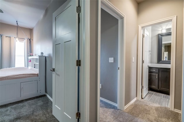 hall with baseboards and carpet flooring