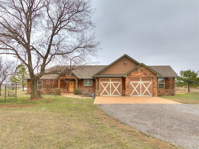 view of front of house with driveway, stone siding, roof with shingles, an attached garage, and a front yard