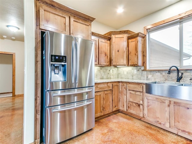 kitchen featuring tasteful backsplash, a sink, and stainless steel fridge with ice dispenser