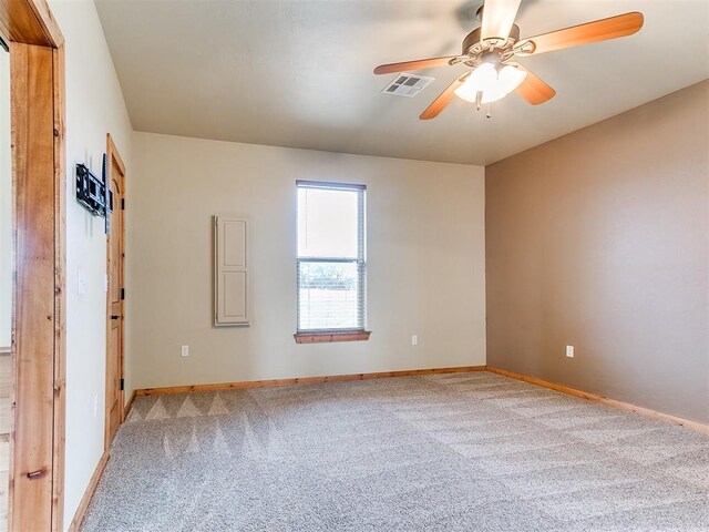 spare room featuring ceiling fan, baseboards, visible vents, and light colored carpet