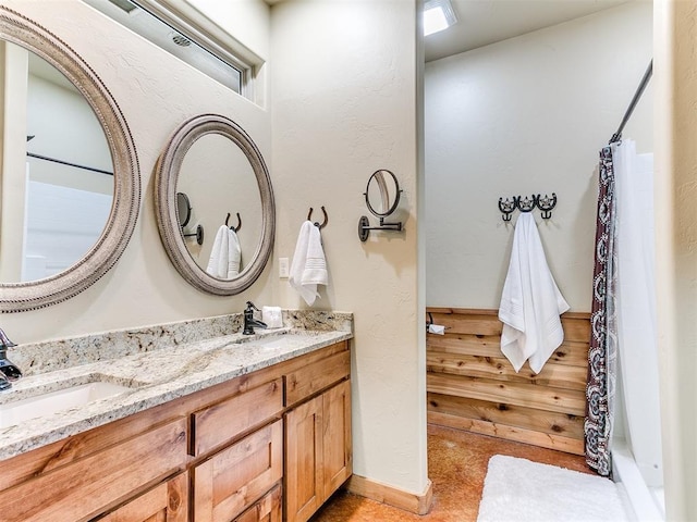 full bath featuring double vanity, curtained shower, and a sink