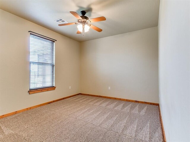 spare room featuring baseboards, visible vents, a ceiling fan, and light colored carpet