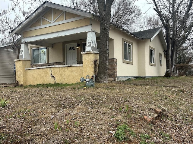 view of front of property with a shingled roof and stucco siding