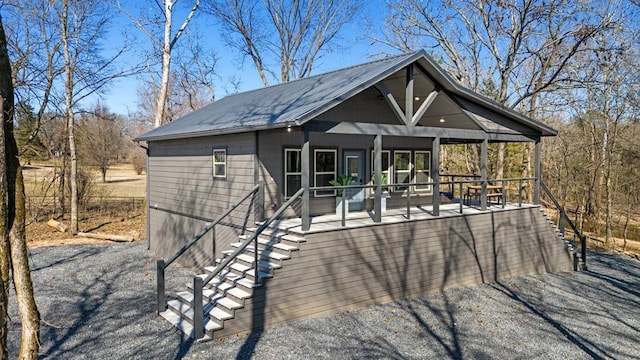 view of front of property featuring metal roof and stairway