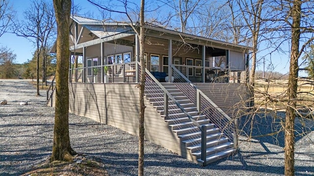 view of front of home with a porch, metal roof, and stairway