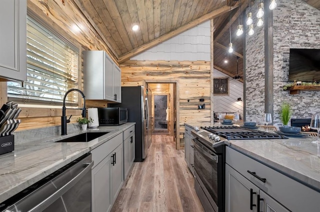 kitchen featuring wooden ceiling, appliances with stainless steel finishes, light stone counters, vaulted ceiling, and a sink