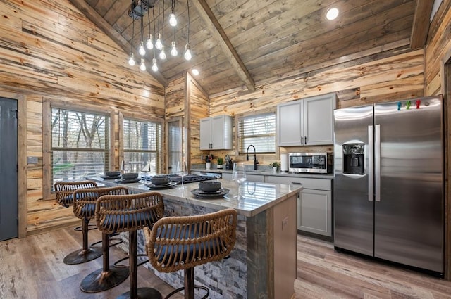 kitchen with stainless steel appliances, light wood-type flooring, wooden ceiling, and wood walls