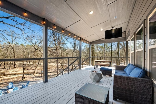 wooden terrace featuring an outdoor living space with a fire pit