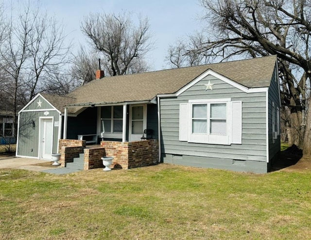 view of front of home featuring brick siding, roof with shingles, crawl space, a front lawn, and a chimney