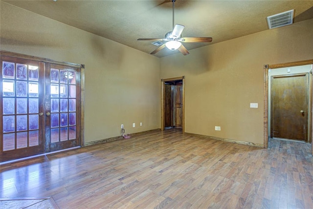 empty room featuring french doors, wood finished floors, and visible vents