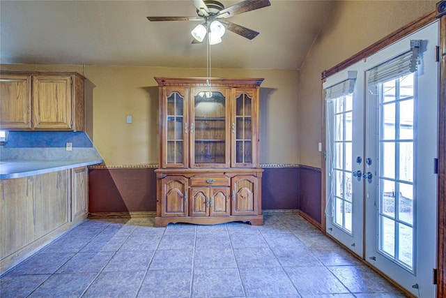 unfurnished dining area with ceiling fan, french doors, vaulted ceiling, and plenty of natural light