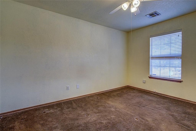 carpeted spare room with a textured ceiling, a ceiling fan, visible vents, and baseboards