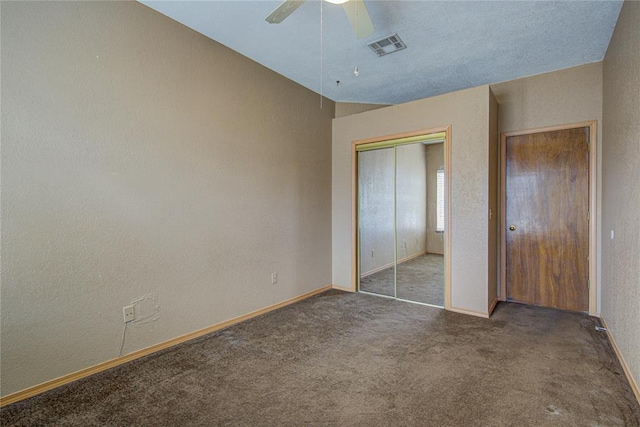 unfurnished bedroom featuring a textured wall, a closet, carpet flooring, and baseboards