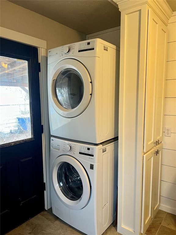 laundry area with stacked washer / dryer and laundry area