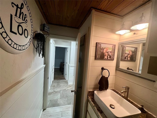 bathroom featuring a sink and wood ceiling