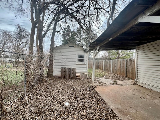 view of yard featuring fence, a carport, and an outdoor structure