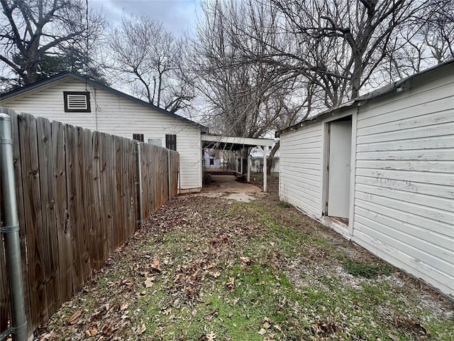 view of yard featuring a carport and fence