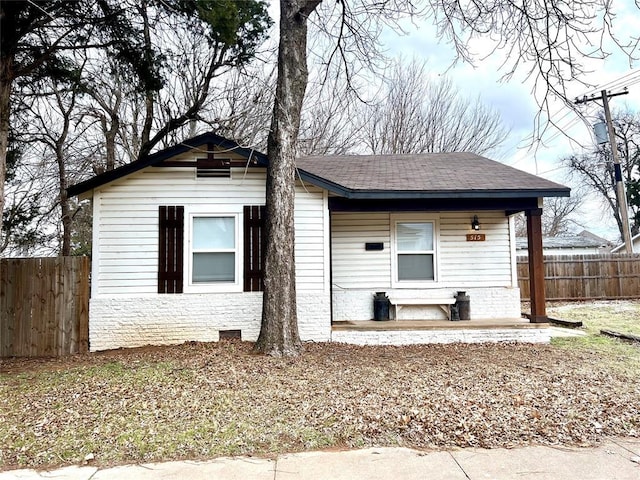 view of front of home featuring a shingled roof and fence