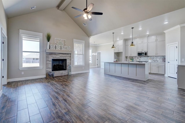 kitchen featuring a ceiling fan, open floor plan, stainless steel microwave, and plenty of natural light