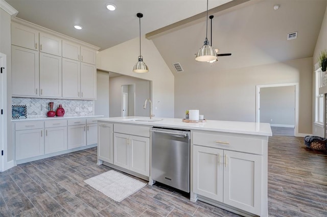 kitchen with tasteful backsplash, visible vents, vaulted ceiling, a sink, and dishwasher