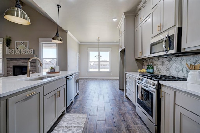 kitchen with appliances with stainless steel finishes, light countertops, a sink, and tasteful backsplash