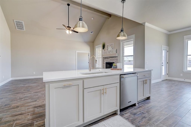 kitchen featuring a stone fireplace, a sink, visible vents, open floor plan, and light countertops