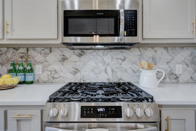 kitchen with light countertops, appliances with stainless steel finishes, backsplash, and white cabinets