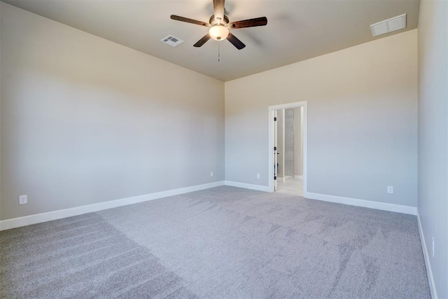 carpeted empty room featuring visible vents, ceiling fan, and baseboards