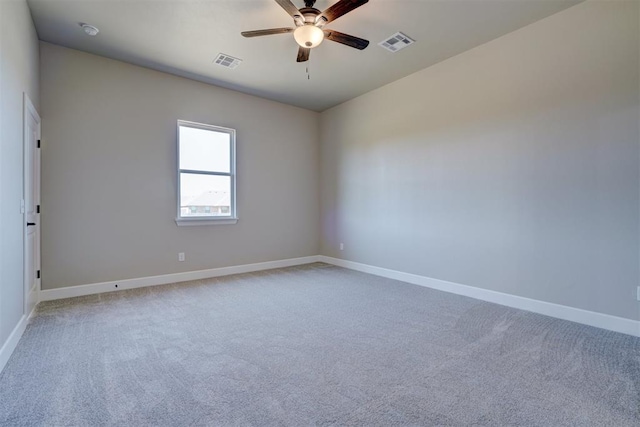 spare room with baseboards, visible vents, and a ceiling fan