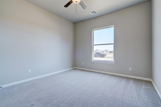 empty room with light carpet, ceiling fan, visible vents, and baseboards