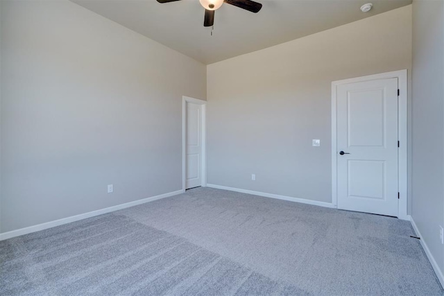 empty room featuring ceiling fan, carpet flooring, and baseboards