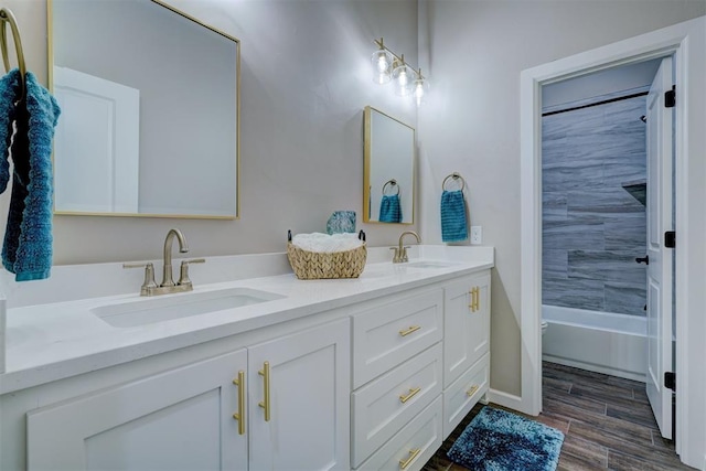 bathroom featuring double vanity, wood finished floors, and a sink