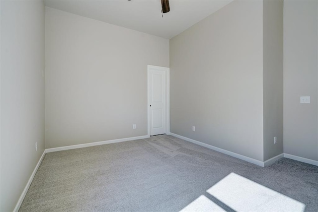 spare room featuring a ceiling fan, baseboards, and carpet flooring