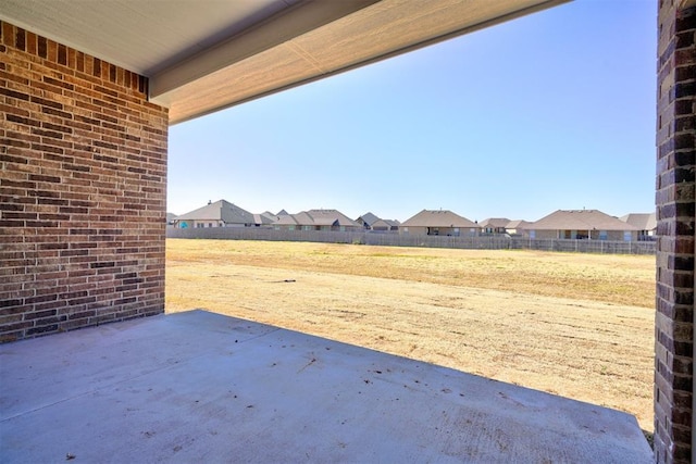 view of patio with fence and a residential view