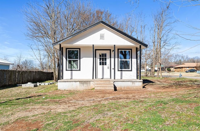 bungalow with a front lawn, fence, and a porch