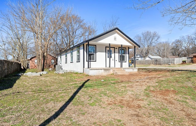 bungalow-style home with covered porch, central AC unit, a front yard, and fence