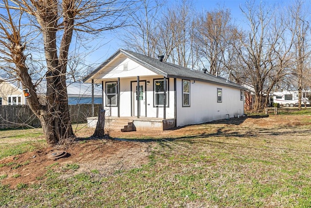 bungalow-style house with covered porch, fence, and a front yard