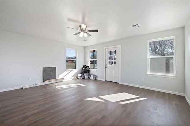 interior space with ceiling fan, wood finished floors, visible vents, and baseboards