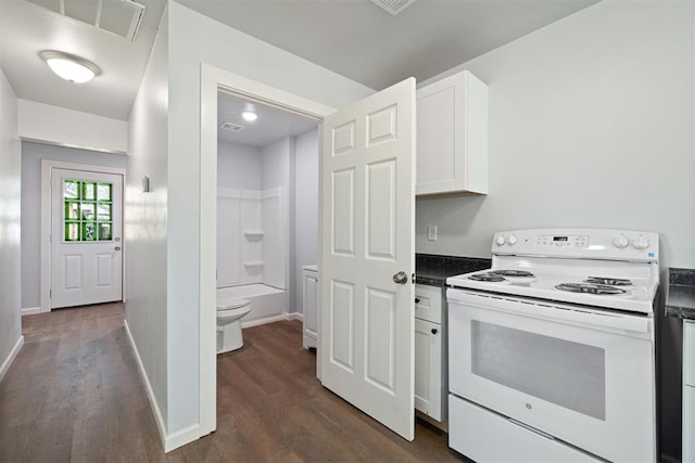 kitchen with dark countertops, white cabinets, visible vents, and white electric range oven